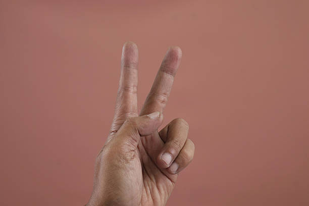 istock Faceless man doing the peace sign with her fingers 2239638041