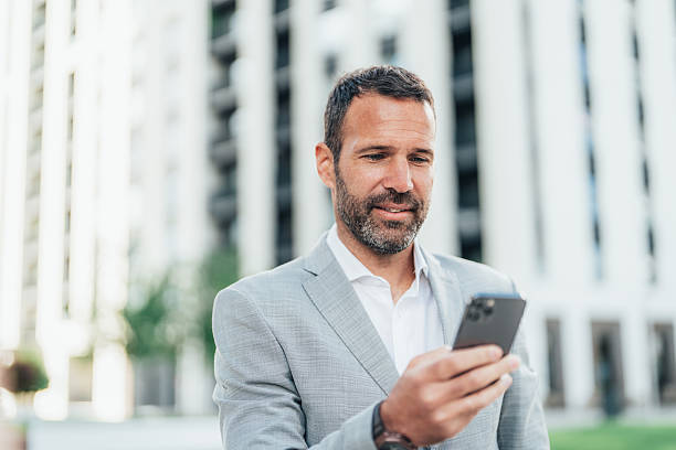 istock Cheerful businessman texting 2239646261