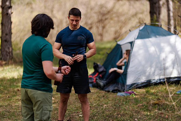 istock Friends enjoying a camping trip in a wooded area while setting up their tent and preparing for outdoor activities during a warm afternoon 2239648455