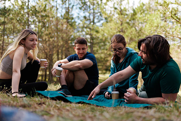istock Friends enjoying a relaxing camping experience in a green forest under the warm sunlight while sharing stories and drinks 2239648505