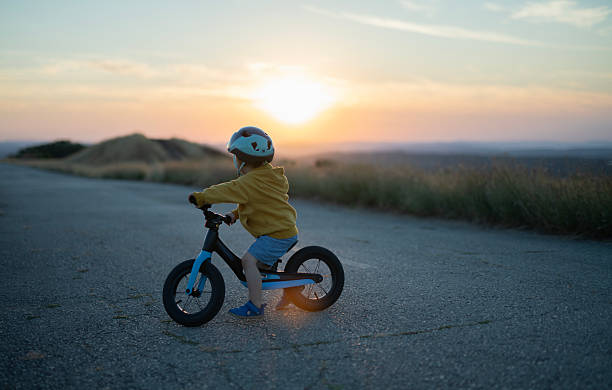 istock Cute little boy riding a bike at sunset. 2239648577