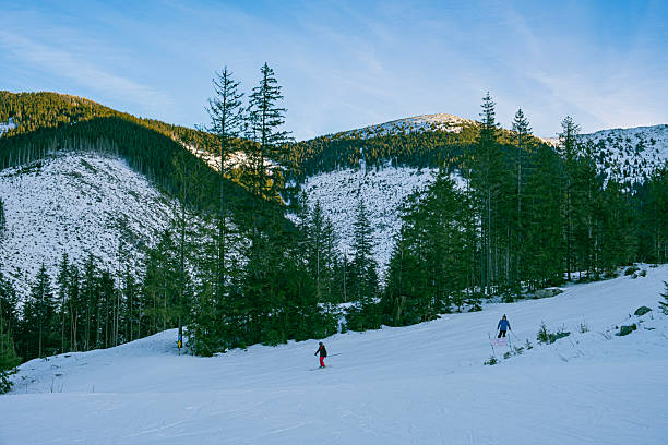 Skiers racing down a snowy slope in the Slovakian mountains