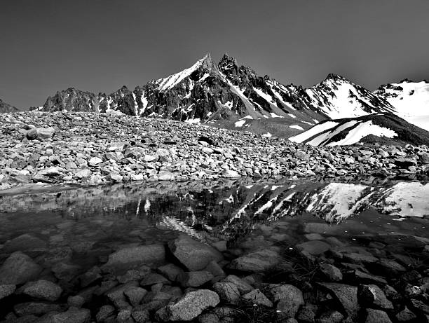 View across calm lake with ripple circle and mountain reflection, Engadine Alps, Graubunden Canton, Swiss Alps