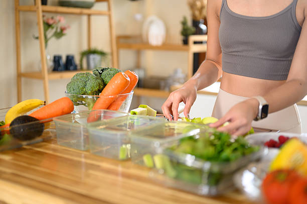 istock Fitness woman packing nutritious ingredients or weekly meal prep in a bright kitchen 2239662349
