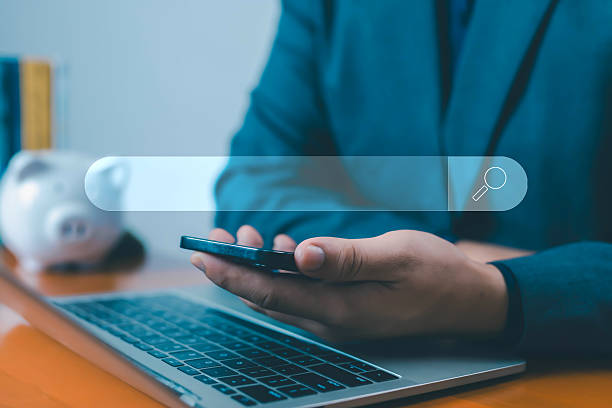 istock Businessman using smartphone and laptop with digital search bar icon, representing online search, internet browsing, SEO marketing, and digital business technology research, business analysis, 2239665992