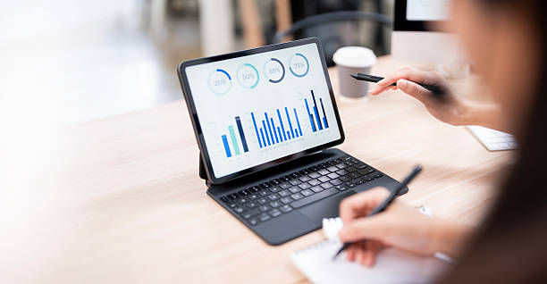 istock business meeting or a student study session. One person points to a bar graph on a tablet screen 2239669437