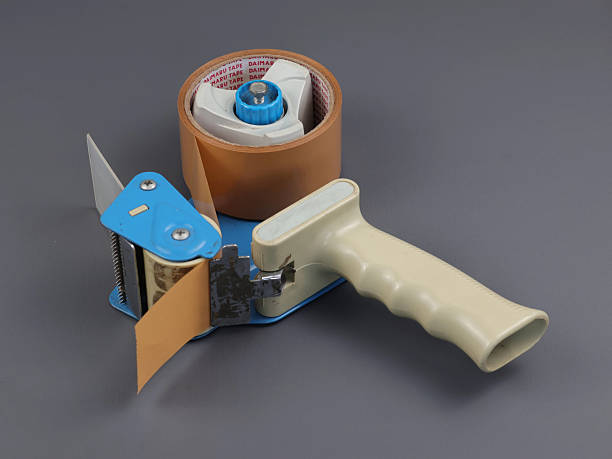istock Parcel tape dispenser with brown roll of tape 2239674298