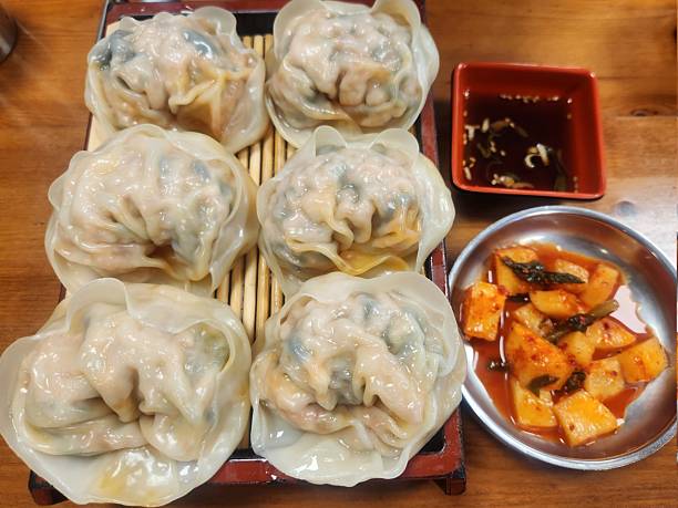 istock Steamed or fried mandu dumplings served alongside fermented kimchi, creating a classic Korean pairing that combines savory, tender dumplings with spicy, tangy, and flavorful fermented vegetables 2239676177