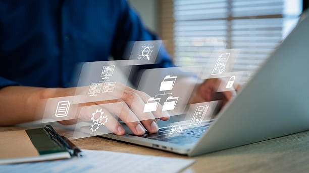 istock ERP document management concept. Businessman working on laptop computer with icons on virtual screen. 2239679790