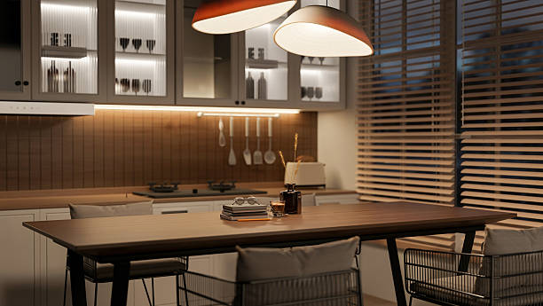 istock Coffee cup and book on wooden table with chairs in kitchen or dining room with blinds covered window 2239680230