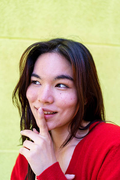 Young woman keeping a secret glancing away