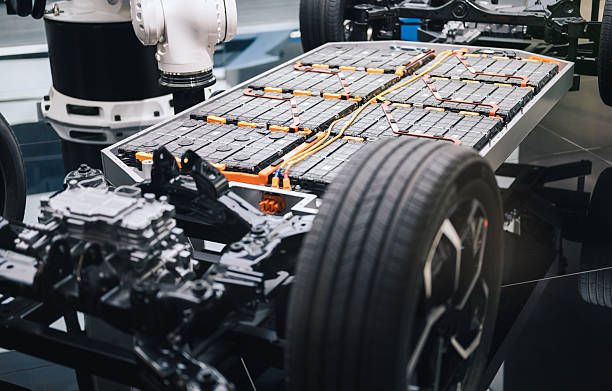 lectric vehicle chassis with battery modules being fitted during the assembly process. Showcasing EV platform engineering, automotive manufacturing, renewable energy storage, sustainable transport technology, and next generation mobility production.
