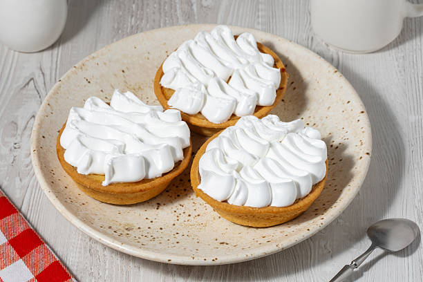istock Cream-filled cakes on a light wooden table 2239682605