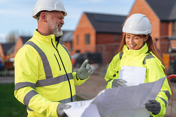istock Construction team reviews blueprints in residential development site  for new housing project 2239692447