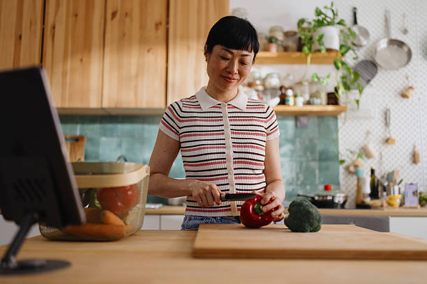 istock Woman cutting vegetables and chatting with a recipe chatbot 2239693024
