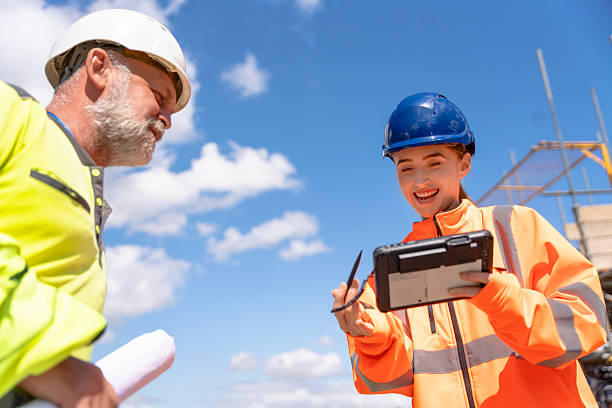 istock Site manager and woman builder discussing works progress on construction site 2239693081