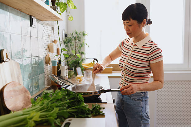istock Woman stirring vegetables in a frying pan 2239693098