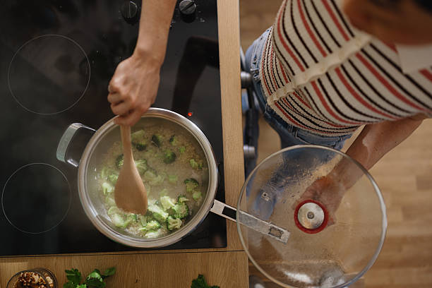 Woman stirring vegetables in a frying pan