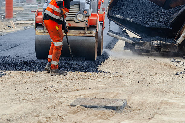 istock Construction workers in high-visibility gear are applyin gfresh hot asphalt to roadway surface 2239697354