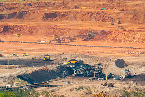 istock Massive Coal Mining Operation inside the Mae Moh Lignite Mine, Lampang, Thailand. Heavy Machinery, Large Dump Trucks, and Conveyor Belts working in a dusty Open-Pit Mine under Daylight. 2239697364