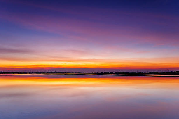 istock Spectacular Twilight Sky with Vibrant Colors and Dramatic Clouds perfectly Reflected on Calm Water or Lake Surface. Serene Landscape at Dusk or Dawn. 2239697390