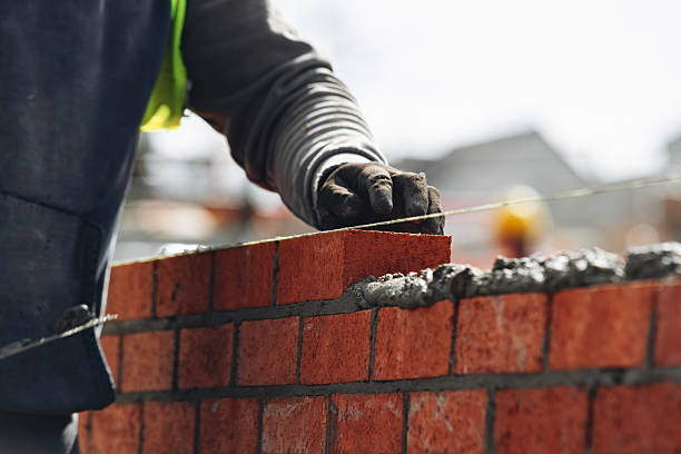 istock Close-up of Bricklayer laying red bricks on building site 2239700792