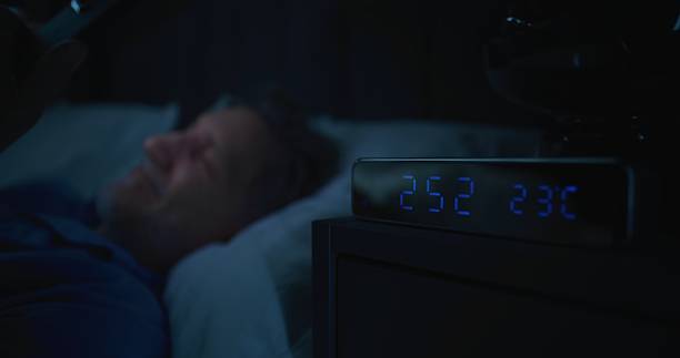 istock Mature Man in Bed Illuminated By Smartphone Screen, Digital Clock Showing Two AM 2239702233