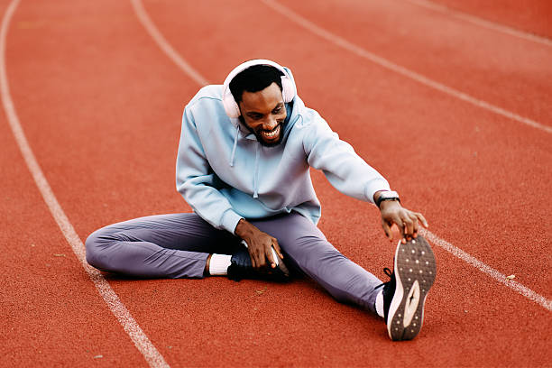 istock Happy man stretching leg on running track 2239702963