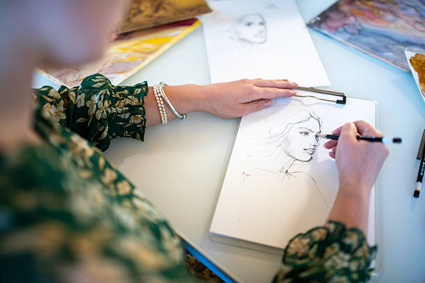 istock Painter artist young woman in her home studio: Drawing on table 2239703509