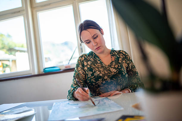 istock Painter artist young woman in her home studio: Drawing on table 2239703584