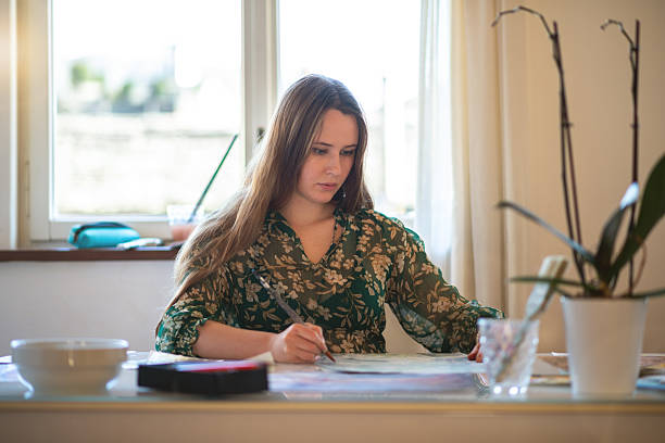 istock Painter artist young woman in her home studio: Drawing on table 2239703776