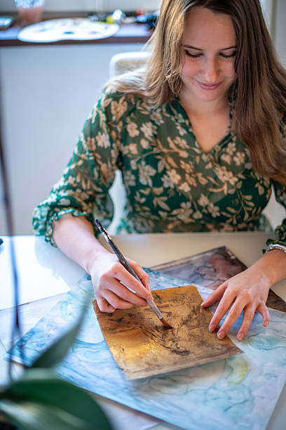istock Painter artist young woman in her home studio: Drawing on table 2239704003