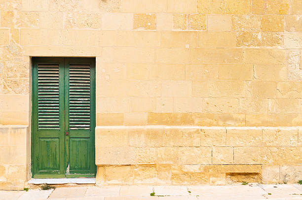 Stone brick wall with a green wooden door.