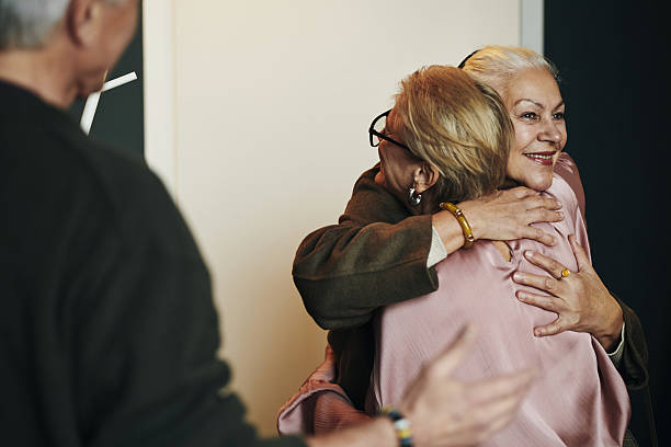 istock Senior Women Embracing While Smiling during Warm Reunion Indoors 2239707018