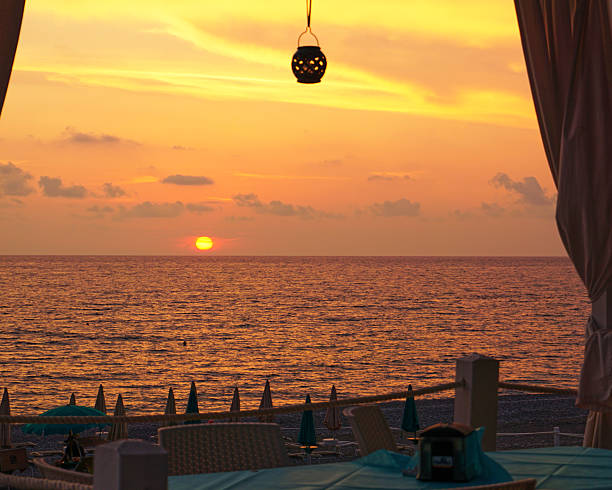 Beautiful view of the sunrise, sunset over the sea horizon with a pier in the foreground, where the sea is blurred