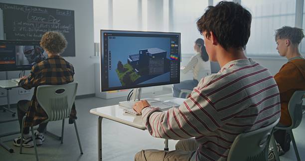 istock Young Man with Dark Hair Concentrates on 3D House Design at Computer in Classroom 2239710505