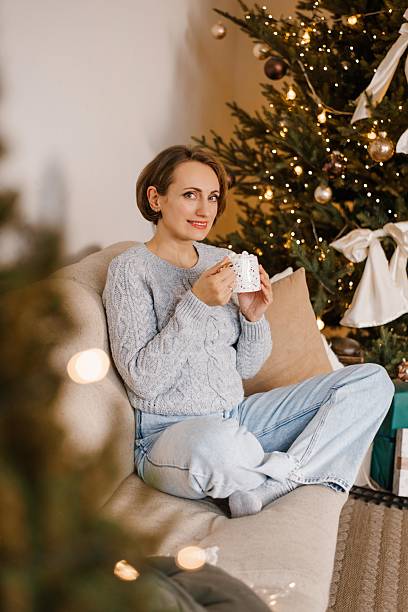istock Woman Relaxing With Cup By Christmas Tree 2239713134