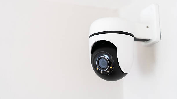 istock A camera is mounted on a wall. The camera is black and white. The camera is pointed at the viewer 2239715493