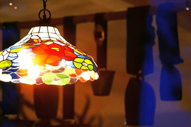 istock view through a window with reflections on a stained glass lamp with a decorative shade hanging in a rustic setting 2239715687