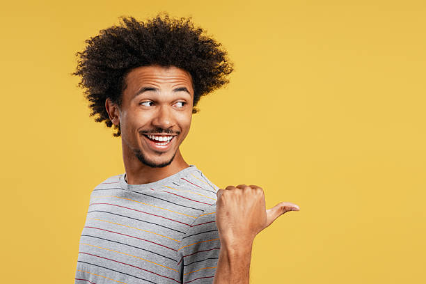 istock Happy black man pointing thumb to the side 2239716517