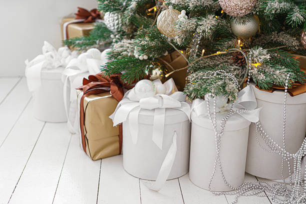 istock Wrapped holiday gift boxes under beautifully decorated Christmas tree with white and gold ornaments 2239718073