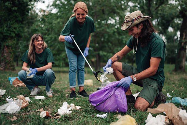 istock Volunteers cleaning park, picking up trash for environment 2239718181