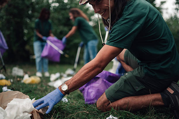 istock Volunteers cleaning park, picking up trash for environment 2239718188