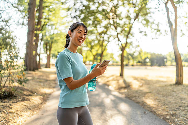 istock Young asian woman pausing during workout using smartphone 2239724389