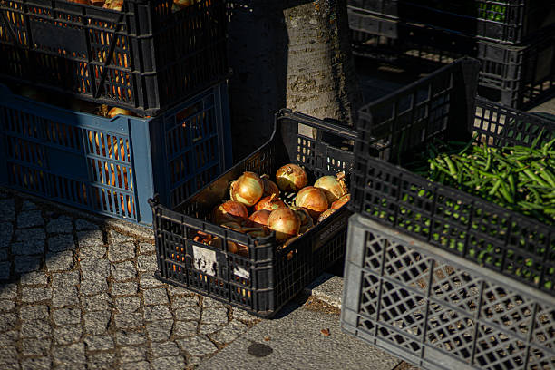 Fresh onions displayed on a small local farmers' market stall, showcasing vibrant colors and natural textures, ideal for culinary and agricultural themes.