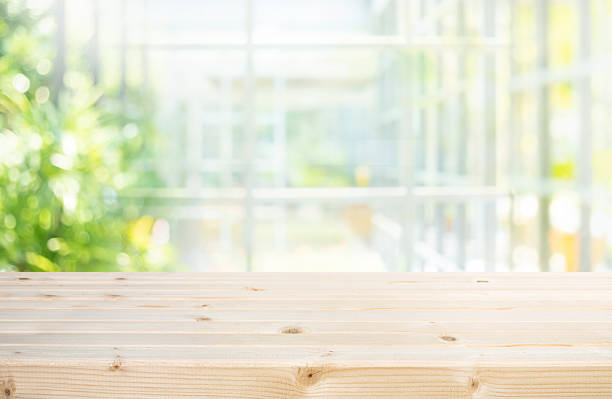 istock Selective focus.Wood table top,counter top with beautiful blur big glass wall texture with fresh garden 2239728348