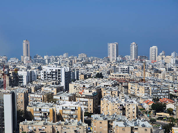 istock Urban view with densely packed buildings extending to sea horizon under blue sky, highlighting contrast between city and natural elements 2239730010