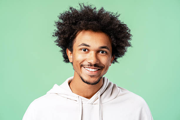 istock Young black man smiling at camera against green background 2239730928