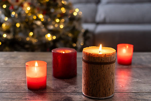 istock Red Christmas candles with holiday lights and tree in background 2239734777