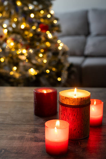istock Red Christmas candles with holiday lights and tree in background 2239734808